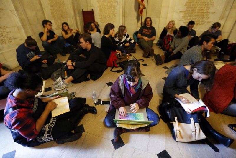 Students gather inside Nassau Hall during a sit-in, Thursday, Nov. 19, 2015, in Princeton, N.J. The protesters from a group called the Black Justice League, who staged a sit-in inside university President Christopher Eisgruber’s office on Tuesday, demand the school remove the name of former school president and U.S. President Woodrow Wilson from programs and buildings. CREDIT: Julio Cortez, AP