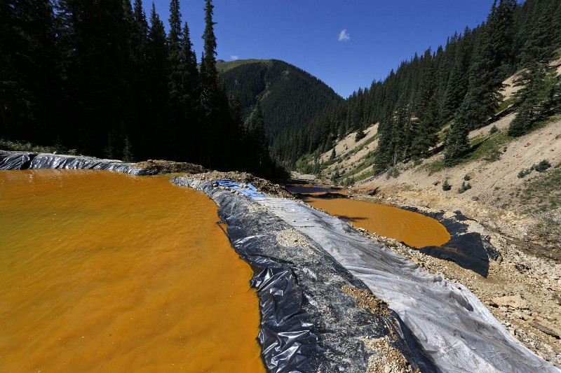 In this Aug. 14, 2015 photo, water flows through a series of sediment retention ponds built to reduce heavy metal and chemical contaminants from the Gold King Mine wastewater accident, in the spillway about 1/4 mile downstream from the mine, outside Silverton, Colo. CREDIT: AP PHOTO/BRENNAN LINSLEY