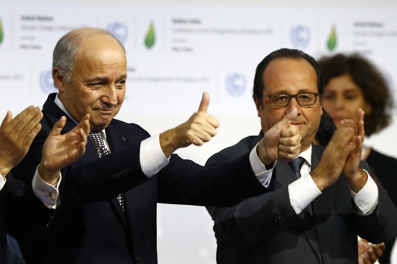 French President Francois Hollande, right, and French Foreign Minister and president of the COP21 Laurent Fabius react after the final conference at the COP21, the United Nations conference on climate change, in Le Bourget, north of Paris, Saturday, Dec.12, 2015. Governments have adopted a global agreement that for the first time asks all countries to reduce or rein in their greenhouse gas emissions. CREDIT: AP PHOTO/FRANCOIS MORI