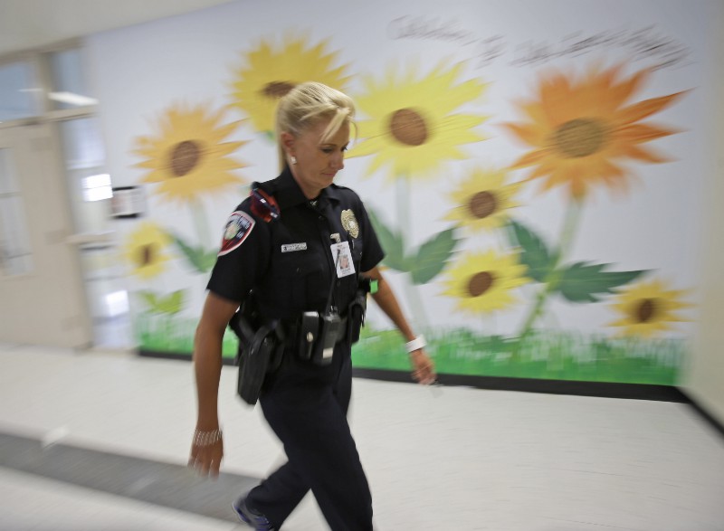 In this photo taken Thursday, Aug. 22, 2013, Dara Van Antwerp, the school resource officer at Panther Run Elementary School Pembroke Pines, Fla. walks the hallways of the school where she teaches in the Gang Resistance And Drug Education (GRADE) program. CREDIT: WILFREDO LEE