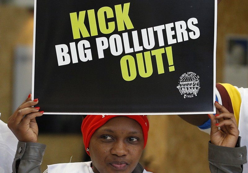 An activist protesting against polluters holds a banners at the Climate Generations Areas, part of the COP21, the United Nations Climate Change Conference Wednesday, Dec. 2, 2015 in Le Bourget, north of Paris. CREDIT: AP PHOTO/CHRISTOPHE ENA