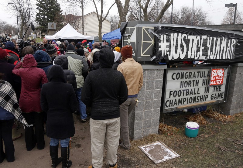 Protesters listened as Nekima Levy-Pounds, center, president of the Minneapolis chapter of the NAACP, renewed demands for investigators to release videos of the fatal shooting by Minneapolis police of Jamar Clark, an unarmed black man, while speaking at the Black Lives Matter encampment outside the Minneapolis police department’s Fourth Precinct, Thursday, Nov. 19, 2015, in Minneapolis. (AP Photo/Jim Mone) CREDIT: AP PHOTO/JIM MONE