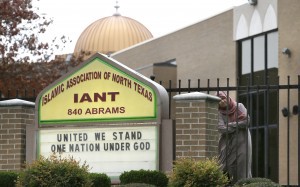 A Muslim woman peers out as protests take place outside a mosque in Richardson, Texas, Dec. 12, 2015. CREDIT: AP Photo/LM Otero