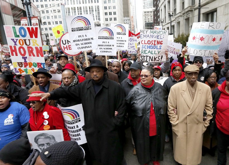 Karen Lewis, center, president of the Chicago Teachers Union is joined by the Rev. Jesse Jackson, left, and U.S. Rep. Bobby Rush, right, during a demonstration and march over the a plan to close 54 Chicago Public Schools. CREDIT: CHARLES REX ARBOGAST