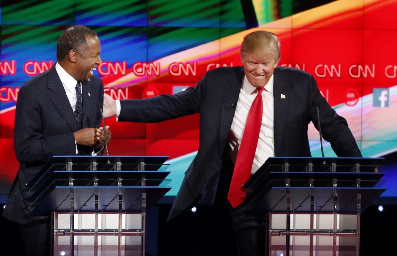 Ben Carson, left, and Donald Trump laugh during the CNN Republican presidential debate at the Venetian Hotel & Casino on Tuesday, Dec. 15, 2015, in Las Vegas. CREDIT: AP PHOTO/JOHN LOCHER