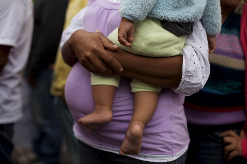 FILE — In this June 3, 2014 file photo, Honduran migrant Velma Flores holds her friend’s 7-month-old son Miguel Antonio while arriving with fellow migrants, escorted by human rights activists, to Mexico City. Flores, who is pregnant and traveling with two young daughters, is one of the vast numbers of Central American migrants undertaking the risky overland crossing through Mexico toward the U.S. (AP Photo/Rebecca Blackwell, File) CREDIT: AP PHOTO/REBECCA BLACKWELL, FILE