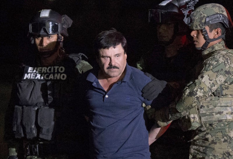 Mexican drug lord Joaquin “El Chapo” Guzman is escorted by army soldiers to a waiting helicopter, at a federal hangar in Mexico City, Friday, Jan. 8, 2016. CREDIT: AP PHOTO/REBECCA BLACKWELL