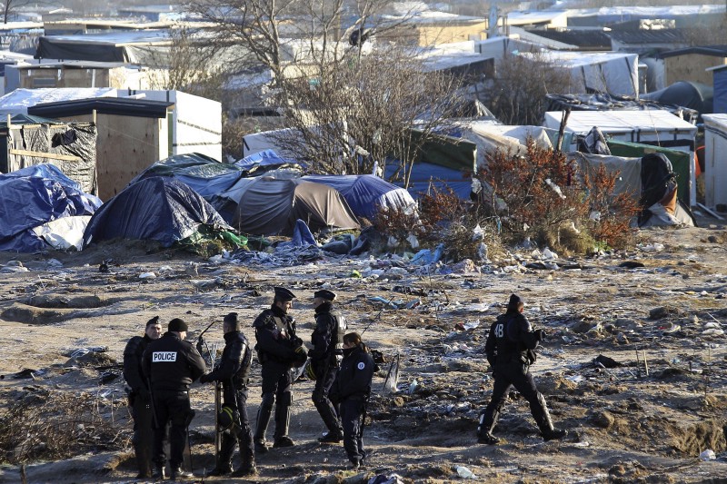 French riot police officers walk in the Calais migrant camp, northern France Thursday, Jan.21, 2016. CREDIT: AP PHOTO/MICHEL SPINGLER
