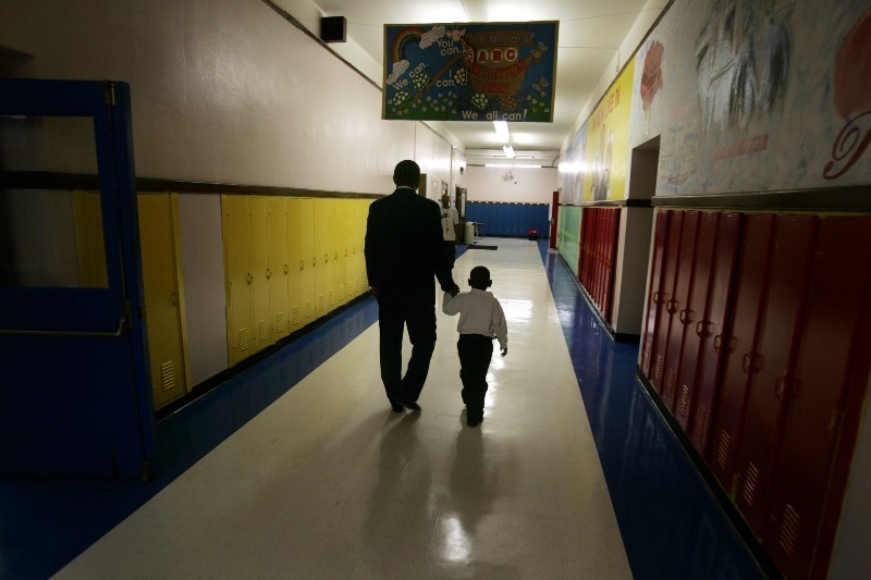 Principal Milton Andrew walks with a kindergarten student to comfort the child during the first day of class at Wilkins Elementary School in Detroit CREDIT: AP PHOTO/CARLOS OSORIO