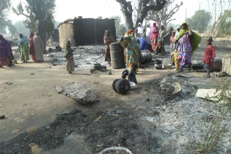 Women and children look at burnt out houses following an attack by Boko Haram in Dalori village, Nigeria on Sunday Jan. 31, 2016. CREDIT: AP Photo/Jossy Ola