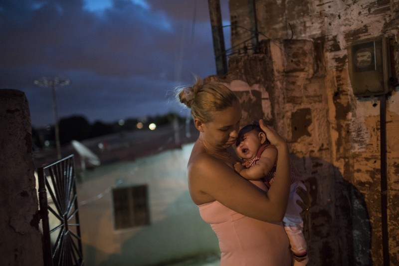 Gleyse Kelly da Silva, holds her daughter who was born with microcephaly, linked to the Zika virus, outside their house in Recife, Pernambuco state, Brazil. CREDIT: AP PHOTO, FELIPE DANA