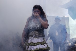 A woman covers her mouth while city workers fumigate insecticide to help combat the Aedes Aegypti mosquitoes that transmit the Zika virus, at the San Judas Community in San Salvador, El Salvador, Tuesday, Jan. 26, 2016. CREDIT: AP Photo/Salvador Melendez