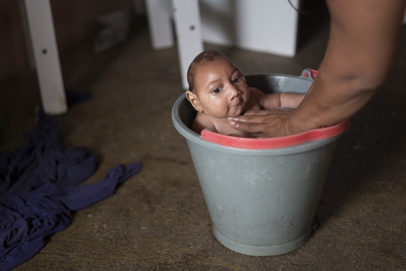 Solange Ferreira bathes her son Jose Wesley in a bucket at their house in Poco Fundo, Pernambuco state, Brazil on Dec. 23, 2015. Ferreira says her son enjoys being in the water, she places him in the bucket several times a day to calm him. CREDIT: AP PHOTO/FELIPE DANA