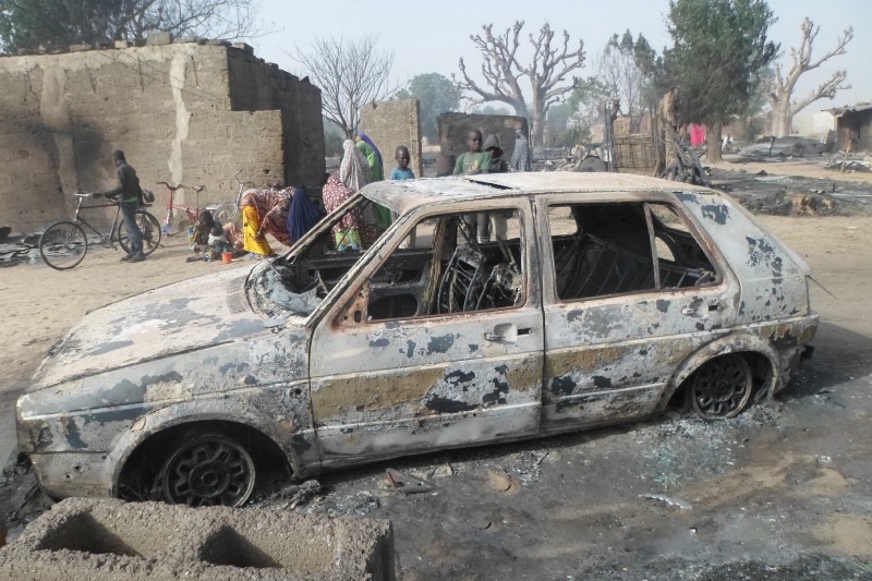 Children gather around a burnt out car following an attack by Boko Haram in Dalori village, Nigeria on Sunday Jan. 31, 2016. CREDIT: AP PHOTO/JOSSY OLA