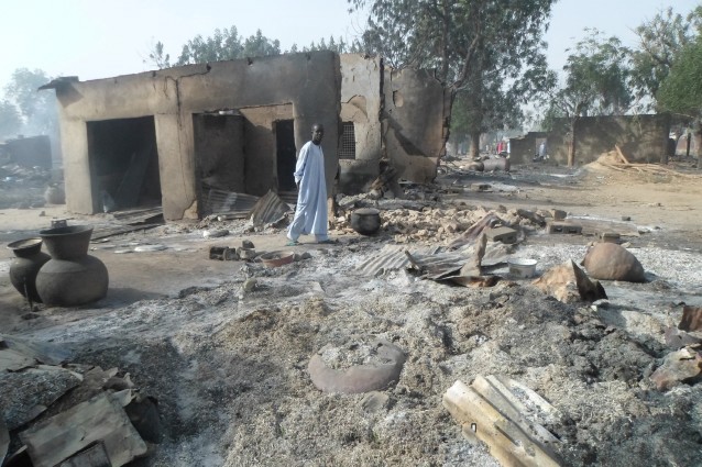 A man walks past burnt out houses following an attack by Boko Haram in Dalori village, Nigeria on Sunday Jan. 31, 2016. CREDIT: AP Photo/Jossy Ola