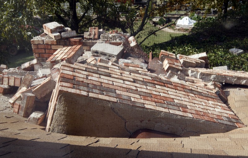 This Sunday, Nov. 6, 2011 file photo of a chimney that toppled and went through the roof at the home of Joe and Mary Reneau are pictured through a second-story screen window in Sparks, Okla. CREDIT: AP PHOTO/SUE OGROCKI,FILE