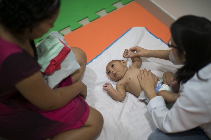 Jaqueline Vieira, left, watches as her 3-month-old son Daniel, who was born with microcephaly, as he undergoes physical therapy at the Altino Ventura foundation in Recife, Brazil, Thursday, Jan. 28, 2016. CREDIT: AP PHOTO, FELIPE DANA