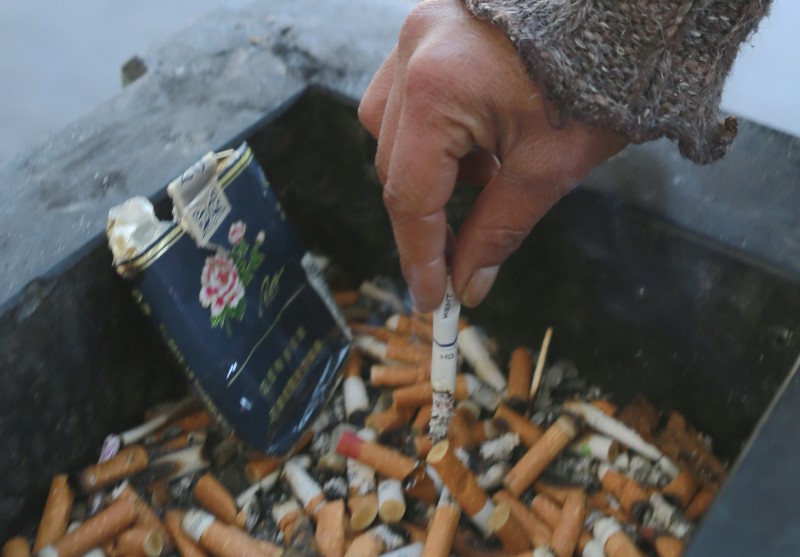 A man stubs out a cigarette in a public ashtray in Paris, France, Thursday, Oct. 1, 2015. CREDIT: AP PHOTO/JACQUES BRINON