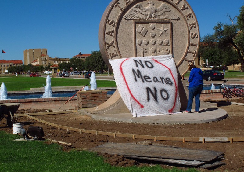Texas Tech freshman Regan Elder helps drape a bed sheet with the message “ No means No,” over the university’s seal on the Lubbock campus on Wednesday, Oct. 1, 2014. CREDIT: BETSY BLANEY, AP