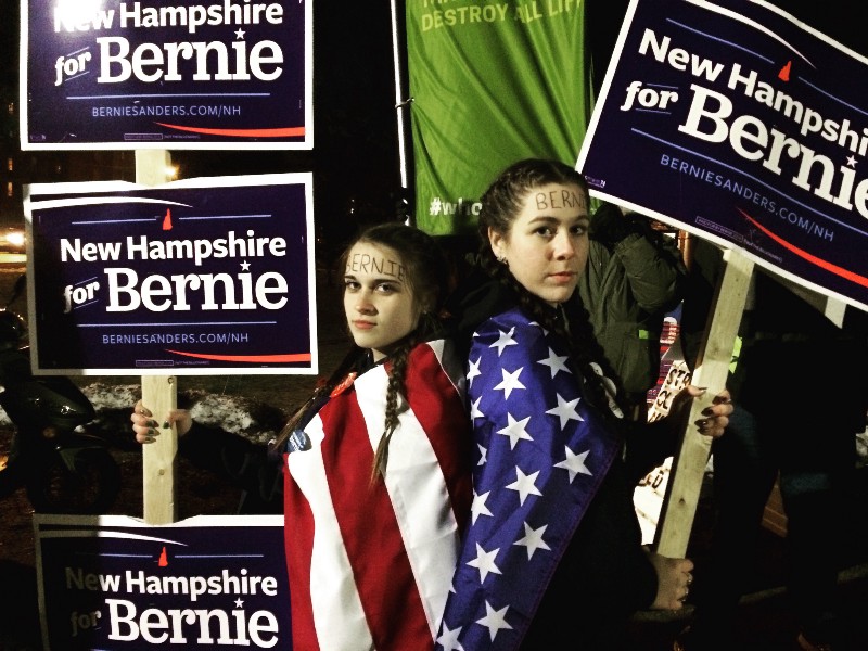 UNH students Emily Wilcox and Summer Auvil demonstrate for Bernie Sanders outside Thursday night’s Democratic debate. CREDIT: ALICE OLLSTEIN