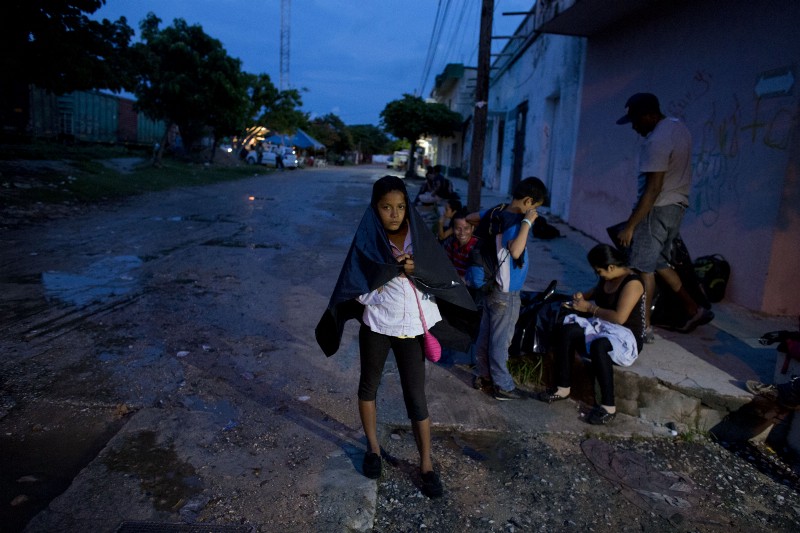 In this Thursday, June 19, 2014 photo, Cynthia Lemus, 12, waits with her family and other Central American migrants, for the arrival of a northbound freight train, in Arriaga, Chiapas state, Mexico. Cynthia’s father, mechanic Natanael Lemus explained that he wanted to leave San Salvador because extortion made it impossible to earn a living. “If you buy a car, they come to extort you. A machine for the workshop, they come to extort you. If they see you put on some nice pants or sneakers, they come to extort you,” said Lemus. “You can’t work like that. You go bankrupt.” (AP Photo/Rebecca Blackwell) CREDIT: AP PHOTO/REBECCA BLACKWELL