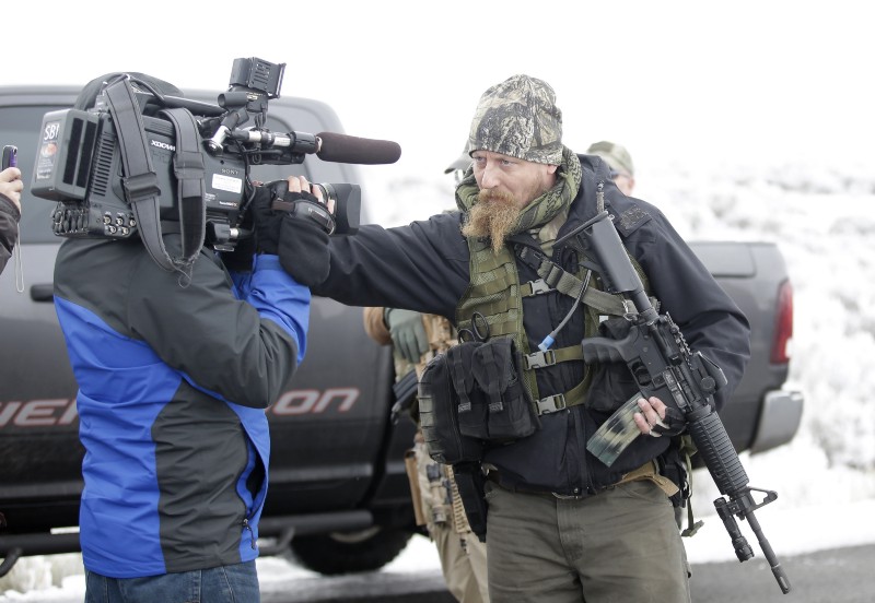 A militiaman and a videographer outside the Malheur National Wildlife Refuge in Harney County, Oregon CREDIT: AP PHOTO/RICK BOWMER