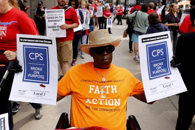 Ronald Jackson, center, pickets outside City Hall to protest $200 million in planned public schools cuts, Thursday, July 2, 2015, in Chicago. CREDIT: Christian K. Lee, AP