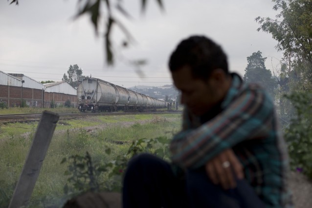 A Central American migrant sits under a tree, as a train arrives from Veracruz into Lecheria, on the outskirts of Mexico City, Wednesday, July 30, 2014. The passage through Veracruz is one of the most dangerous sections of the journey north, and many migrants are robbed, kidnapped, or assaulted there. Many migrants arriving in Lecheria, stop to seek work for several days or longer, in order to earn money for the onward journey. (AP Photo/Rebecca Blackwell) CREDIT: AP Photo/Rebecca Blackwell
