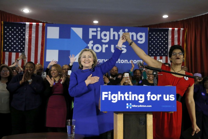 Democratic presidential candidate Hillary Clinton, left, responds to the crowd’s applause after an introductory poem by Geneva Reed-Veal, the mother of Sandra Bland, who was found dead in a Texas jail cell, Wednesday, Feb. 17, 2016, during a campaign stop in Chicago. CREDIT: AP PHOTO/CHARLES REX ARBOGAST)