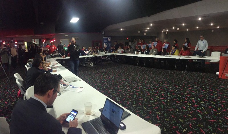 Latino voters listen to Christian Ucles, LULAC’s political director, explain how to caucus.