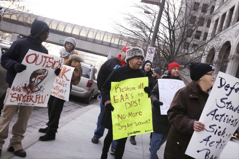 Protesters stand outside Cadillac Place, Monday, Jan. 25, 2016 in Detroit, where a judge is hearing arguments in a case that could force teachers to stop skipping school. CREDIT: Carlos Osorio, AP
