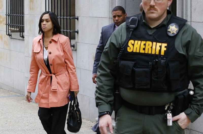 Baltimore State’s Attorney Marilyn Mosby, left, walks out of a courthouse CREDIT: AP PHOTO/PATRICK SEMANSKY