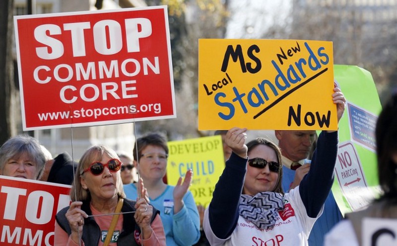 FILE — Common Core opponents wave signs and cheer at a rally opposing Mississippi’s continued use of the Common Core academic standards on the steps of the Capitol in Jackson, Miss. (AP Photo/Rogelio V. Solis,File)