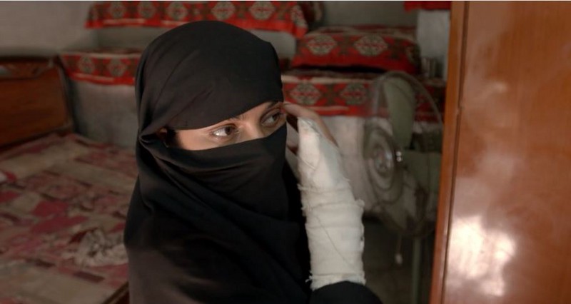 Saba fastens a scarf over her face to hide the scars from a gunshot wound to her face after her family tried to kill her. CREDIT: OBAID CHINOY FILMS/VIMEO