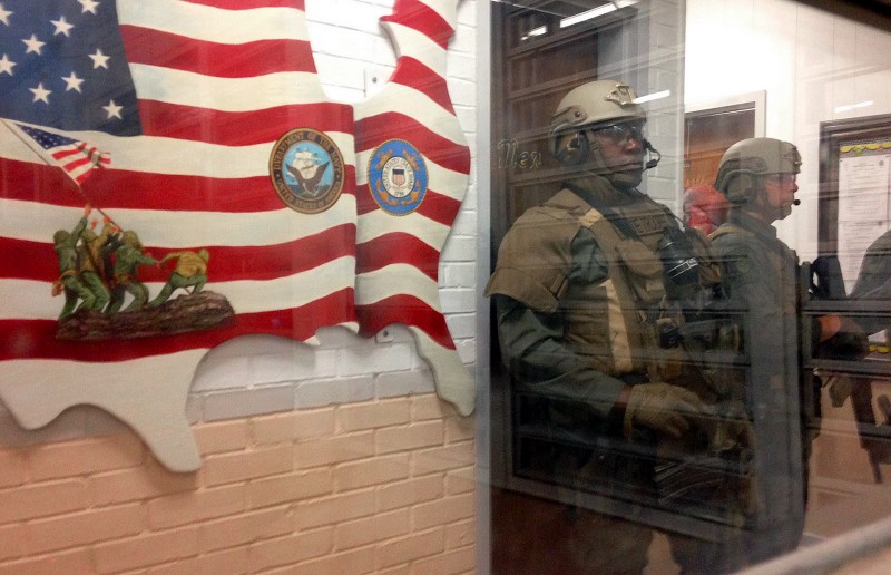 Armed state troopers are seen through a window as they accompany Alabama Gov. Robert Bentley inside Holman prison in Atmore, Ala., on Tuesday, March 15, 2016. Bentley visited the prison in southwest Alabama following two inmate uprisings in four days. Calling the prison archaic, Bentley called on legislators to approve his plan for constructing new prisons. CREDIT: AP PHOTO/MELISSA BROWN