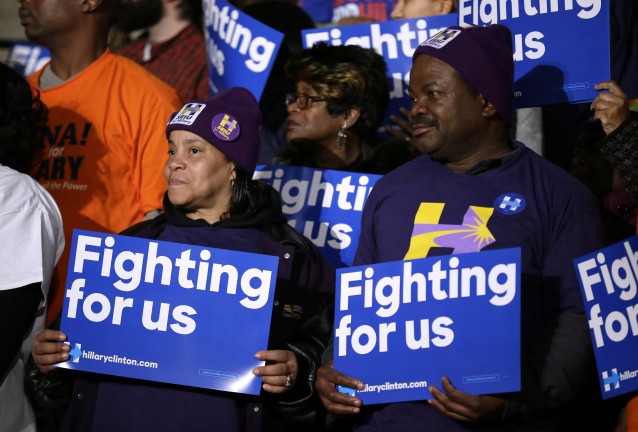 Audience members watch as Hillary Clinton speaks during a rally in Detroit. CREDIT: AP Photo/Charlie Neibergall