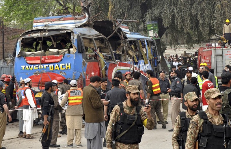 Pakistani soldiers and volunteers surround a bus following a bomb blast in Peshawar, Pakistan, Wednesday, March 16, 2016. CREDIT: AP Photo/Mohammad Sajjad