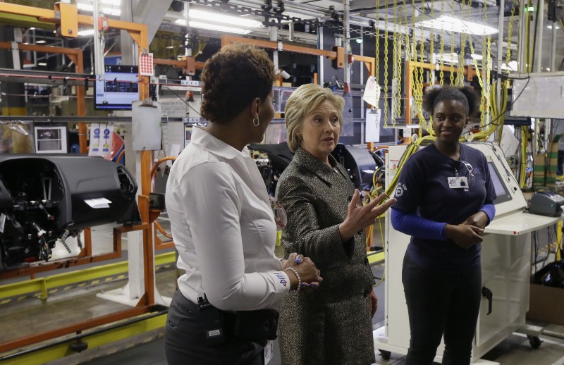 Democratic presidential candidate, Hillary Clinton speaks with Deanne Austin, left, and Victoria Montgomery at the Detroit Manufacturing Systems plant, Friday, March 4, 2016, in Detroit. CREDIT: AP PHOTO/CARLOS OSORIO