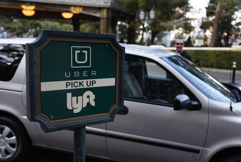 A driver waits to pick up passengers at an Uber and Lyft pick up area at the Bellagio hotel and casino in Las Vegas. CREDIT: AP PHOTO/JOHN LOCHER
