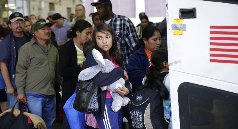 Immigrants from El Salvador and Guatemala who entered the country illegally board a bus after they were released from a family detention center in San Antonio, Tuesday, July 7, 2015. CREDIT: AP PHOTO/ERIC GAY, FILE