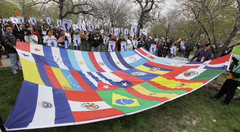 Supporters hold a banner made up of national flags as they gather in Union Park for a rally calling for the legalization of more than 12 million undocumented immigrant workers Friday, May 1, 2009, in Chicago. (AP Photo/M. Spencer Green) CREDIT: AP PHOTO/M. SPENCER GREEN