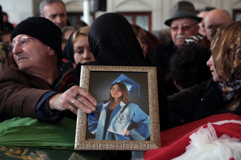 A man places her photograph as family members and friends gather around the bridal veil and Turkish flag-draped coffin of Zeynep Basak Gursoy, 19, one of 37 victims of Sunday’s explosion, during the funeral procession in Ankara, Turkey, Tuesday, March 15, 2016. CREDIT: AP Photo/Burhan Ozbilici