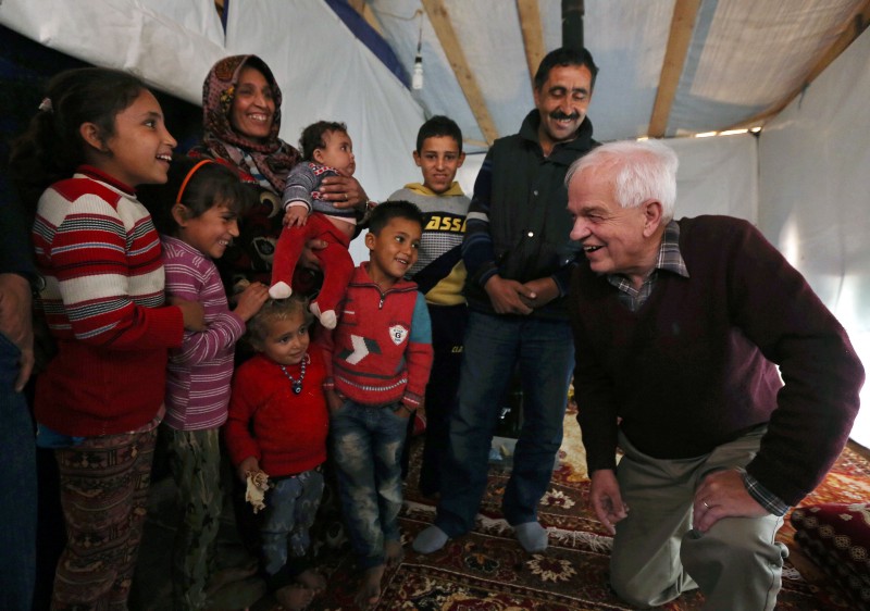 Canadian Minister of Immigration John McCallum speaks with a Syrian family inside their tent, during his visit to a refugee camp in the southern town of Ghaziyeh, near Sidon, Lebanon, Friday, Dec. 18, 2015. CREDIT: AP PHOTO/BILAL HUSSEIN