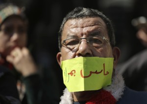 An Egyptian doctor covers his mouth with a paper reading, “I feel painful,” during a protest against rampant police abuses in front of their headquarters of the Egyptian Medical Syndicate in Cairo, Egypt, Friday, Feb. 12, 2016. CREDIT: AP Photo/Amr Nabil