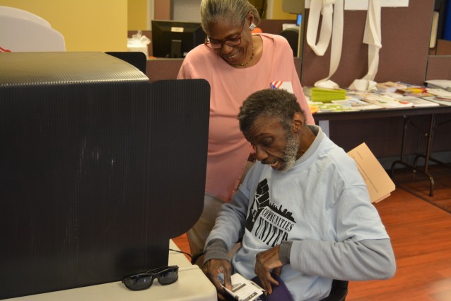 Reggie Smith is aided by a poll worker as he casts his ballot. CREDIT: Kira Lerner