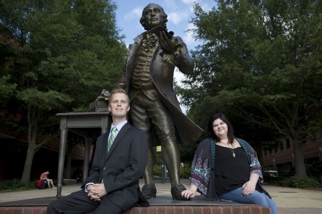 In this photo taken Oct. 7, 2015, George Mason University students Colin Nackerman, left, and Samantha Parson, poste for a portrait by the George Mason statue on campus in Fairfax, Va. George Mason University, a public school outside the nation’s capital, has quietly become a conservative powerhouse in economics and law, a reputation built in part with tens of millions of dollars a year from billionaire Republican donor Charles Koch. CREDIT: Jacquelyn Martin, AP