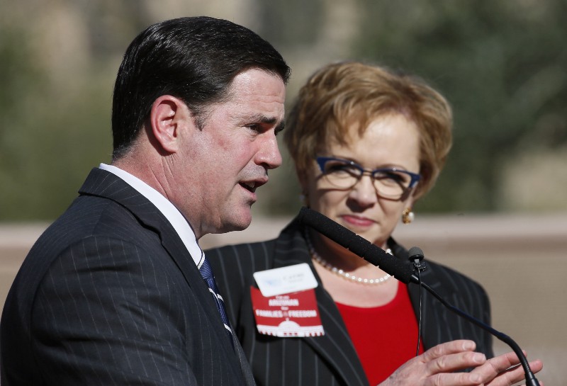 Arizona Gov. Doug Ducey (R) speaks at a 2015 event hosted by the anti-abortion Center for Arizona Policy, as CAP President Cathi Herrod listens, CREDIT: AP PHOTO/MATT YORK