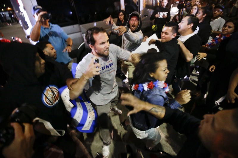 A Trump supporter clashes with protesters outside a rally for Republican presidential candidate Donald Trump, Thursday, April 28, 2016 in Costa Mesa, Calif. CREDIT: AP PHOTO/CHRIS CARLSON