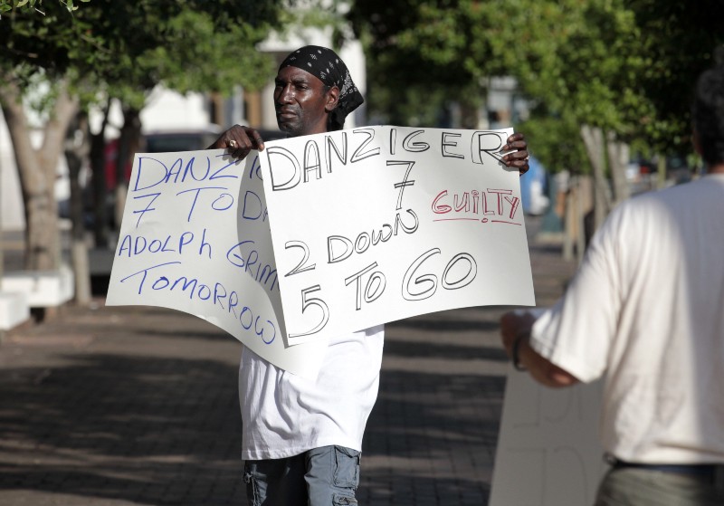 Tabari Simpson, of the group ‘Community United for Change,’ protests outside Federal court in New Orleans, Monday, June 27, 2011, on the opening day of the trial for five current or former New Orleans police officers charged in deadly shootings of unarmed residents on the Danziger bridge in Hurricane Katrina’s chaotic aftermath. Five former officers already have pleaded guilty to participating in a cover-up to make it appear that police were justified in fatally shooting two people and wounding four others. CREDIT: AP PHOTO/GERALD HERBERT