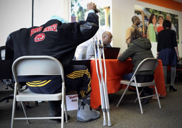A man with crutches signs up for health coverage at Access Health CT, Monday, March 31, 2014, in New Britain, Conn. CREDIT: AP Photo/Jessica Hill